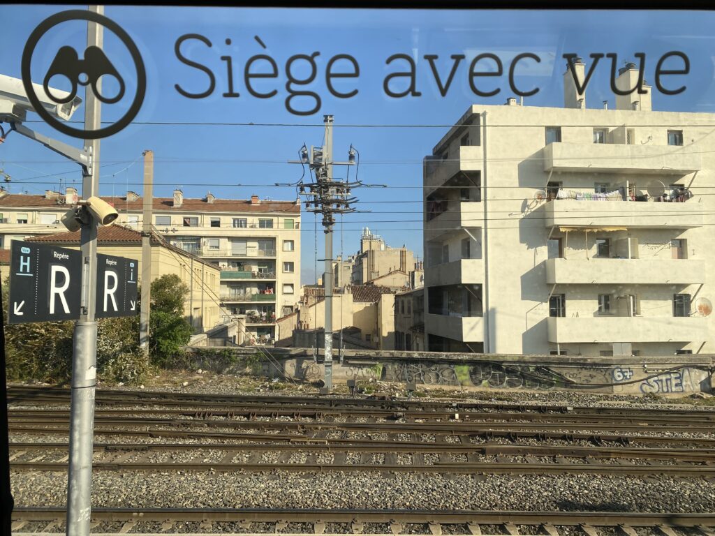 Marseille : la gare sous l'œil des caméras

À Marseille, la gare Saint-Charles est bien plus qu'un simple carrefour de voyageurs ; elle est devenue, au fil des années, un symbole discret mais puissant de la surveillance de masse. Chaque jour, des milliers de passagers franchissent ses escaliers monumentaux, traversent ses quais, passent sous les voûtes en pierre... sans vraiment prêter attention aux dizaines d'yeux électroniques qui les observent.

Depuis les années 2010, en réponse à la menace terroriste et à la montée des insécurités urbaines, le réseau de caméras de la gare s'est densifié. À cela s'ajoute l'intelligence artificielle, capable d'analyser les flux, de détecter des comportements "anormaux", voire d'anticiper des incidents. Un sac abandonné, un mouvement de foule, un comportement jugé suspect : tout est scruté, enregistré, évalué.

Pour certains, cette surveillance est rassurante : elle protège. Pour d'autres, elle pose des questions profondes sur nos libertés. À Marseille, dans le bruissement des trains et le chant des cigales au loin, la gare Saint-Charles incarne cette tension contemporaine entre sécurité et vie privée.